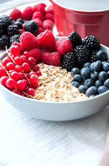 Fresh berries, chocolate balls, and oat granola in a big bowl