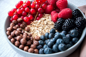 Fresh berries, chocolate balls, and oat granola in a big bowl