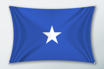 Somalia national flag. Symbol of the country on a stretched fabric with waves attached with pins. Realistic vector illustration.