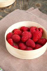 Fresh raspberries in a wooden round box