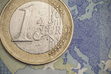 Detailed close up of an one euro coin on a twenty euro banknote, Vintage filtered style