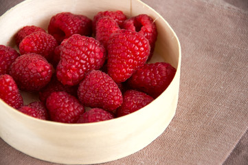 Fresh raspberries in a wooden round box