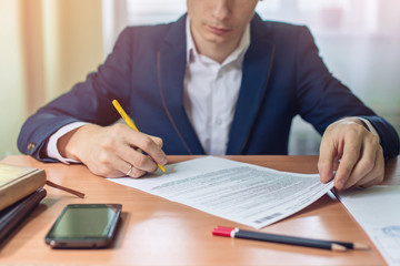Man businessman signs documents with a pen