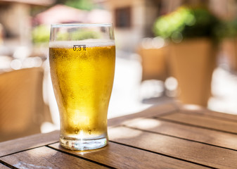 Glass of light beer on the wooden table.