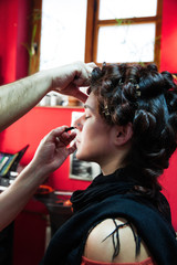 makeup artist apply makeup on young woman