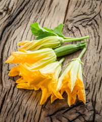 Zucchini flowers on a old wooden table.