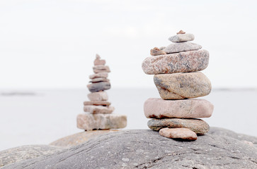 Two piles of stones on the rock, the sea in the background