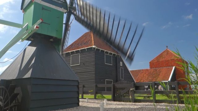 Rotating windmill in front of an old farm at the Zaanse Schans in The Netherlands