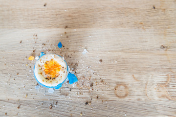 Obraz na płótnie Canvas Kaputtes Osterei nach Eierpicken auf einem Holzbrett mit Salz und Pfeffer