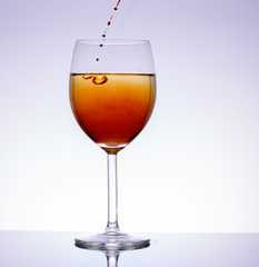 Einfüllen von Alkohol in das Wein - Glas auf weissem Hintergrund