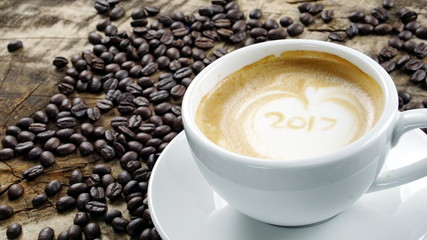 Cappuccino Coffee. A cup of latte, cappuccino or espresso coffee with milk put on a wood table with dark roasting coffee beans. Drawing the foam milk on top.