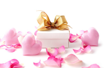 Fototapeta na wymiar gift box, pink hearts and rose petals on white background