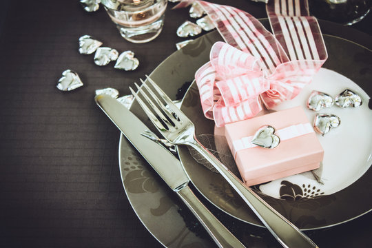 Restaurant series. Valentines day dinner with table setting in pink and gray and holiday elegant heart ornaments
