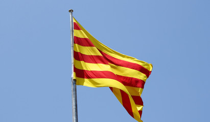 The flag of Catalonia over a blue sky - obrazy, fototapety, plakaty