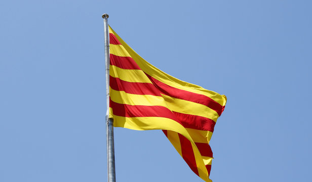 The flag of Catalonia over a blue sky