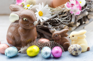 Happy Easter: nest with Easter eggs, feathers, flowers and chocolate bunnies :)