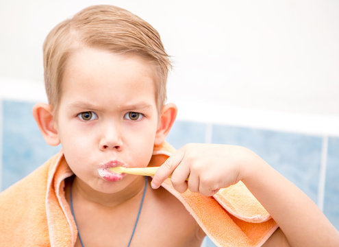 Portrait of a little boy in the bathroom brushing her teeth. Healthy lifestyle, hygiene.