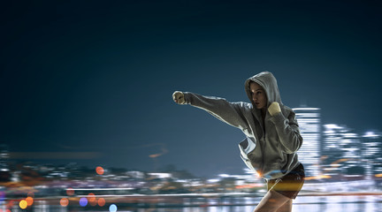 Fototapeta na wymiar Young boxer woman outdoor . Mixed media . Mixed media