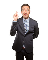 Hopeful businessman finger cross gesture