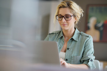 Portrait of blond woman working from home on laptop computer - 136934665