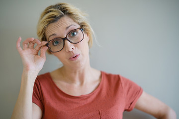 Fototapeta premium Blond woman with eyeglasses having a surprised look