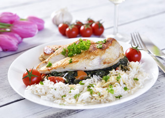 Grilled chicken breast with vegetables, rice and cherry tomatoes. Healthy eating scene, grilled chicken on a white, wooden table with pink tulips.