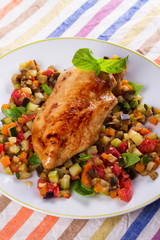 Chicken breast with sauteed vegetables: eggplant, carrot, zucchini, squash and tomatoes