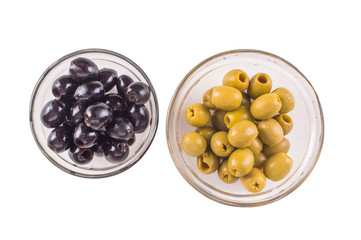 black olives and green olives in a clear glass bowl with a top view