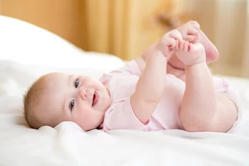 Fototapeten Funny chubby baby infant girl playing with her feet © Oksana Kuzmina