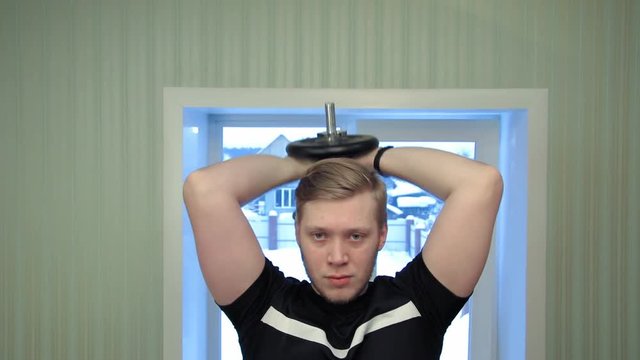 Young man working out his hands lifting dumbels and exercise his biceps