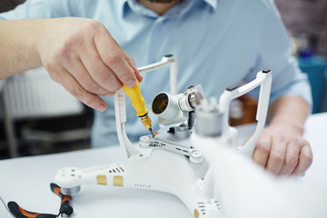 Closeup shot of unrecognizable man working on assembling new spy system using quadrocopter drone on...