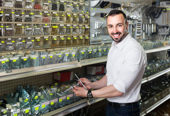  man standing next to showcase with various plastic rawlplugs an
