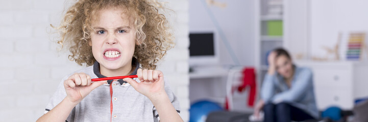Boy breaking a pencil