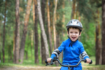 Little kid boy of 3 years and his father in autumn forest with a bicycle. Dad teaching son. Man happy about success. Child helmet. Safety, sports, leisure kids concept