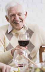 Cheerful elderly man making a toast