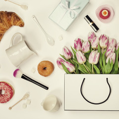 Obraz na płótnie Canvas Top view of spring flowers, coffee, mobile phone, croissants, gi