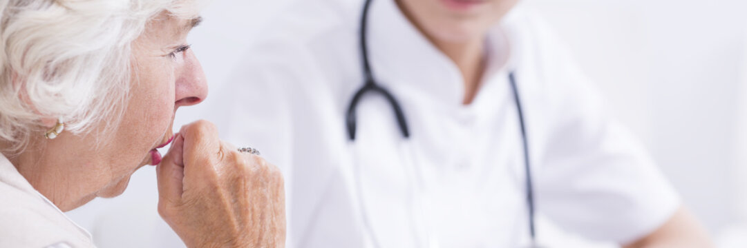 Elderly woman caughing during visit at the doctor
