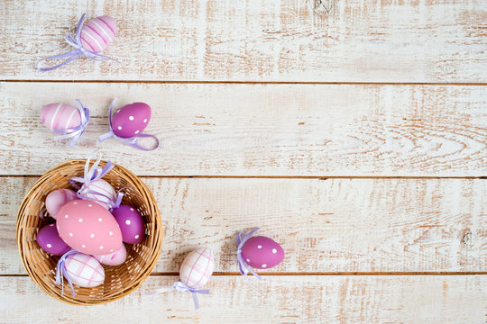 Easter eggs over white wooden vintage table - top view, copy space