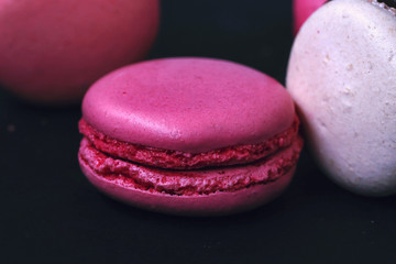 Macaroons on dark background, colorful french cookies macarons. The broken macarons with crumbs. Gift for  8 March -  International Women's Day. Close up picture