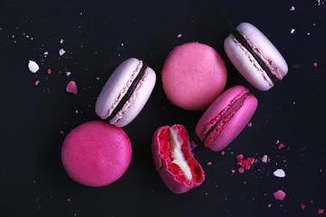 Photo sur Plexiglas Macarons Macarons sur fond sombre, macarons de biscuits français colorés. Les macarons cassés avec des miettes. Cadeau pour la Saint-Valentin et la Journée internationale de la femme du 8 mars