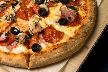 pizza with pepperoni, olives, bacon, mushroom, cheese in the piz