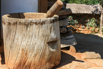 grind grain in a wood mortar
