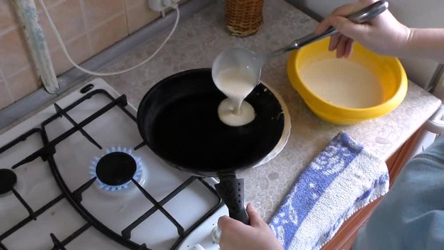 The cook in a frying pan pour the batter for pancakes