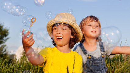 happy boy play in bubbles outdoors
