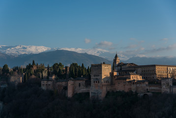 View of Alhambra Palace in Granada, Spain with Sierra Nevada mountains in snow at the background . Granada, Spain