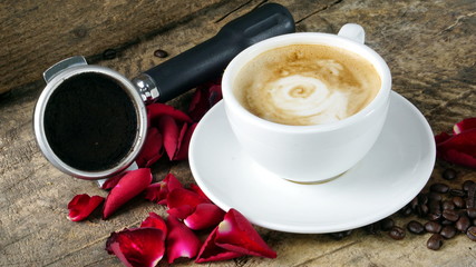 Cappuccino coffee with roses. A cup of latte, cappuccino or espresso coffee with milk put on a wood table with dark roasting coffee beans. Drawing the foam milk on top.