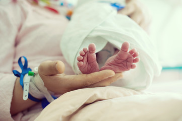 Newborn baby in hospital with id ribbon on his hand