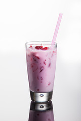 Ice cream cocktail with cranberry juice and raspberries on reflective background.
