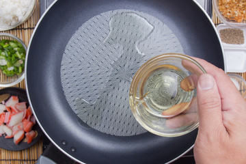 Chef putting oil to the pan