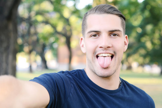 Young latin man taking a selfie in a park.